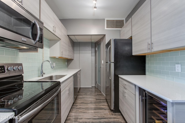 kitchen featuring dark hardwood / wood-style floors, sink, beverage cooler, decorative backsplash, and stainless steel appliances