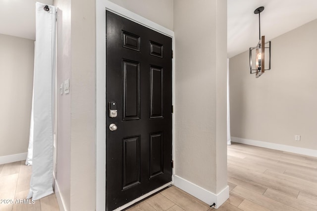 foyer entrance featuring lofted ceiling and light wood-type flooring