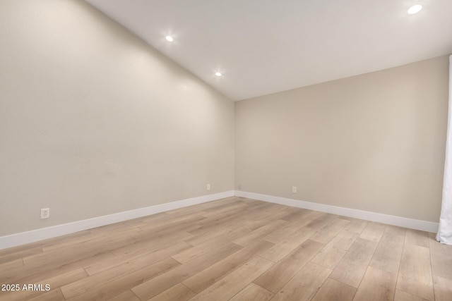 empty room featuring lofted ceiling and light hardwood / wood-style flooring