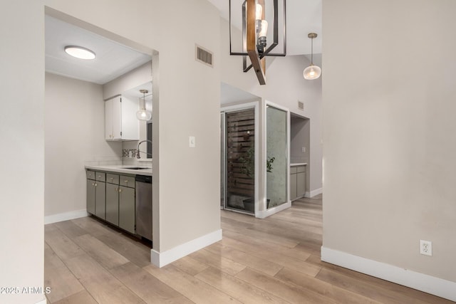 interior space with sink, a high ceiling, and light wood-type flooring