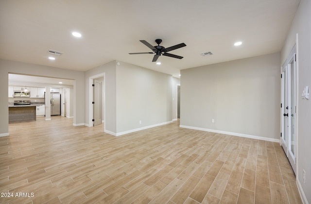 unfurnished living room with ceiling fan and light hardwood / wood-style flooring