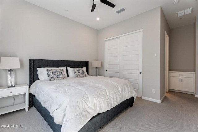 bedroom featuring ceiling fan, a closet, and light carpet