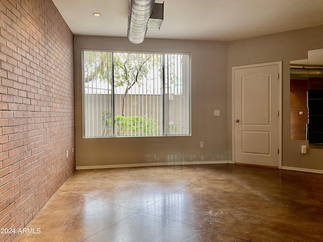 unfurnished dining area featuring brick wall