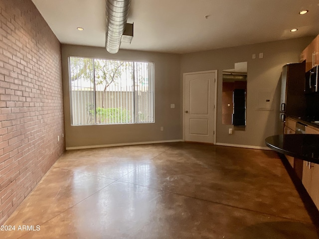 unfurnished dining area with brick wall