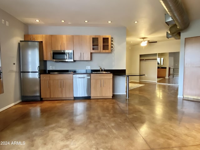 kitchen featuring appliances with stainless steel finishes, sink, concrete floors, and ceiling fan