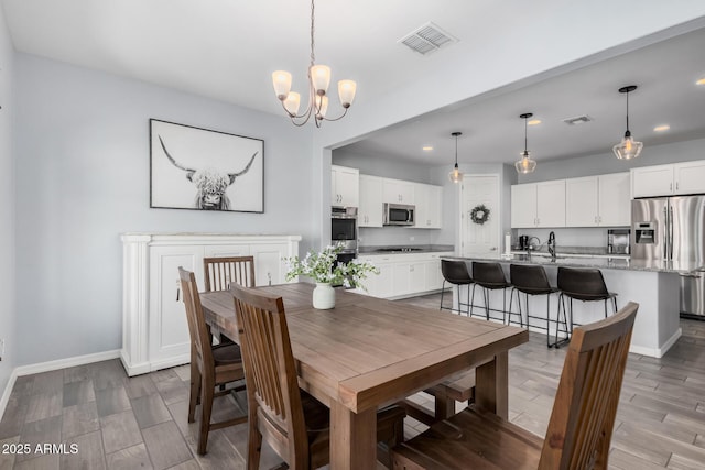 dining space with a notable chandelier and sink