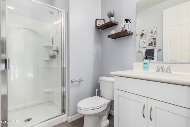 bathroom with vanity, toilet, and a shower with door