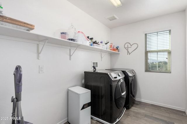 laundry room with wood-type flooring and washing machine and clothes dryer