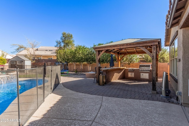 view of patio featuring a gazebo, a fenced in pool, area for grilling, and exterior kitchen