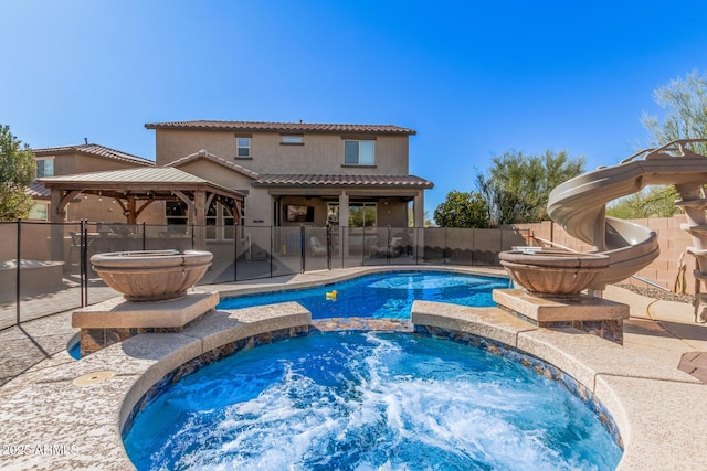 view of swimming pool with a gazebo, an in ground hot tub, and a water slide