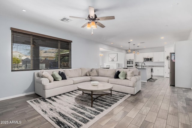 living room featuring ceiling fan and sink