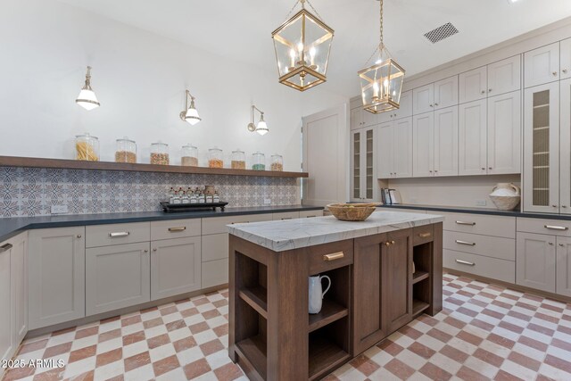 kitchen with light floors, visible vents, open shelves, and a chandelier