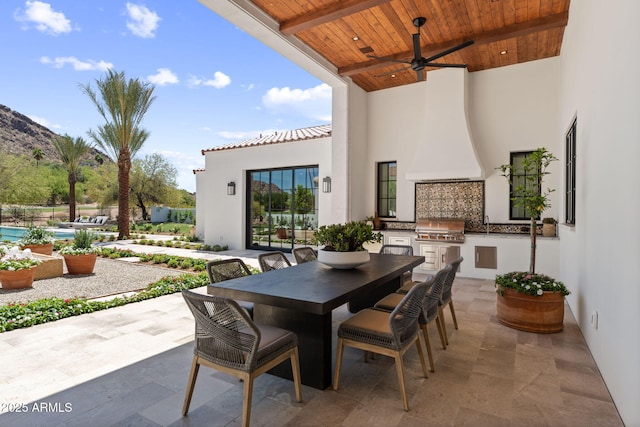 view of patio featuring ceiling fan, grilling area, area for grilling, a mountain view, and outdoor dining area