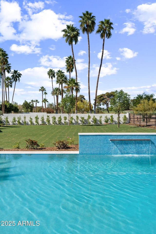 view of swimming pool with a yard and fence