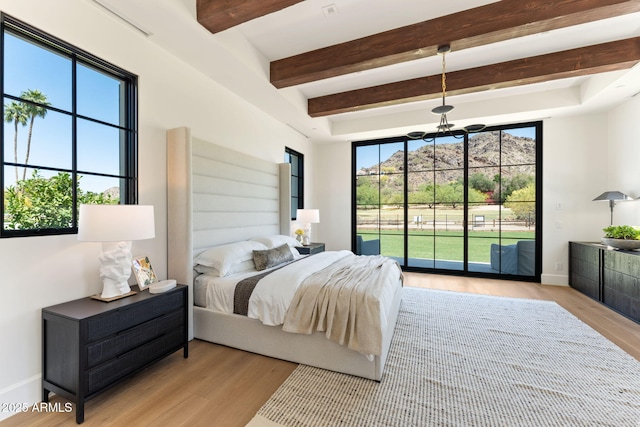bedroom featuring access to outside, beam ceiling, an inviting chandelier, and light wood-style flooring