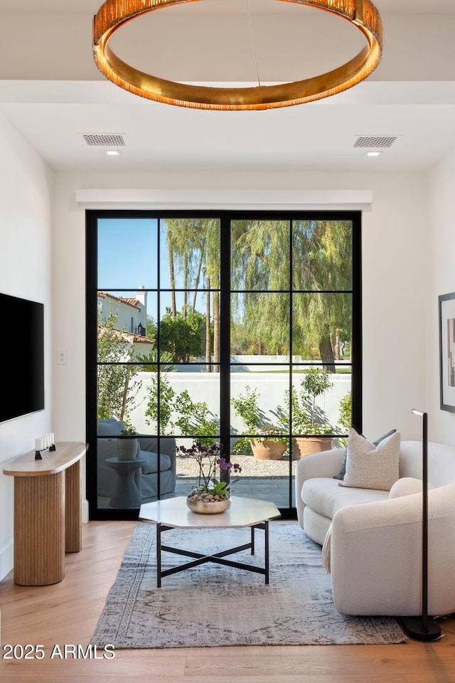 living area featuring visible vents and light wood-style flooring
