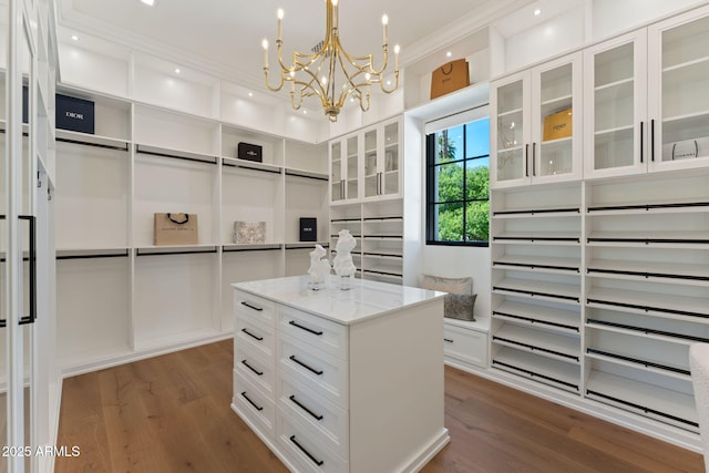 spacious closet featuring a notable chandelier and dark wood-type flooring