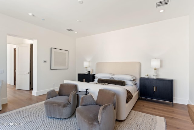 bedroom featuring baseboards, visible vents, and light wood-style floors