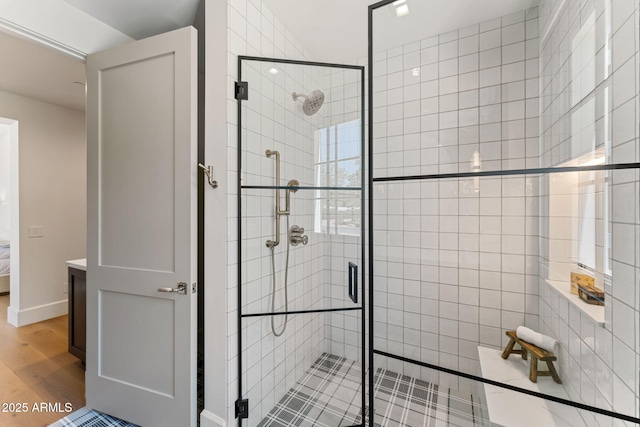 full bathroom featuring wood finished floors and a shower stall