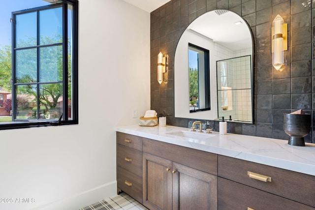 full bathroom featuring vanity, baseboards, and a wealth of natural light