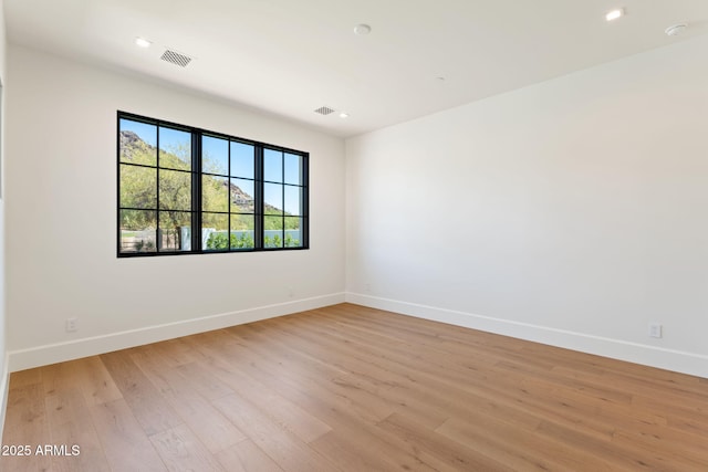 unfurnished room with baseboards, visible vents, and light wood-style floors