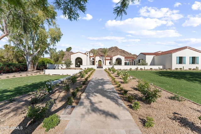 mediterranean / spanish-style house featuring stucco siding and a front yard