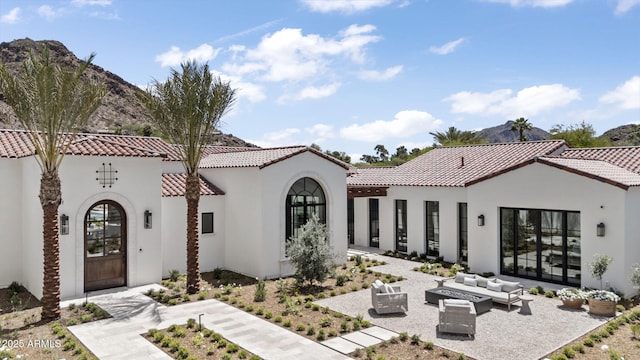 exterior space featuring an outdoor living space with a fire pit, a patio, a tiled roof, and stucco siding