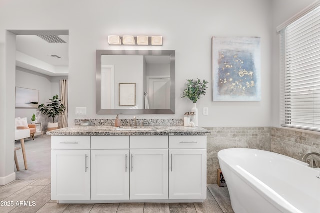 full bathroom with a freestanding bath and vanity