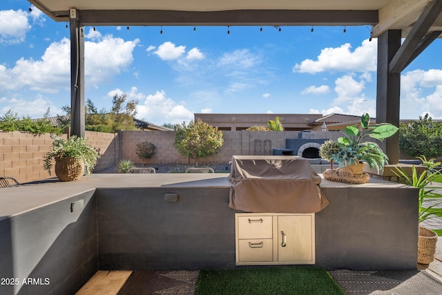 view of patio featuring an outdoor kitchen, a fenced backyard, and a grill