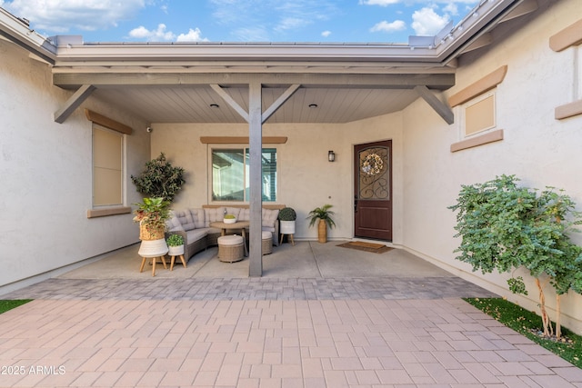 entrance to property with a patio and stucco siding