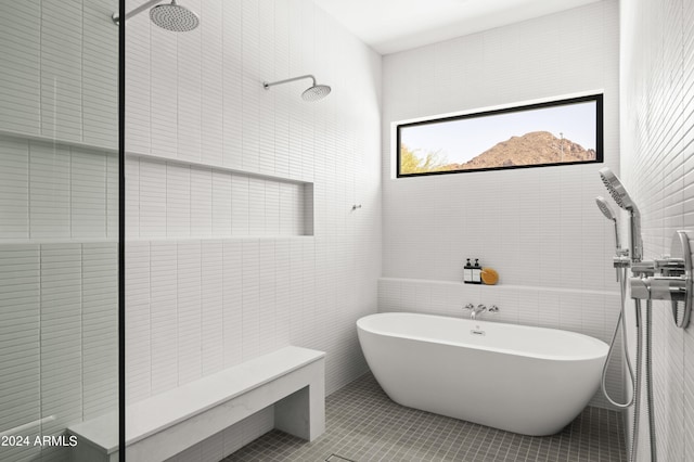 bathroom featuring tile patterned floors, plus walk in shower, and tile walls