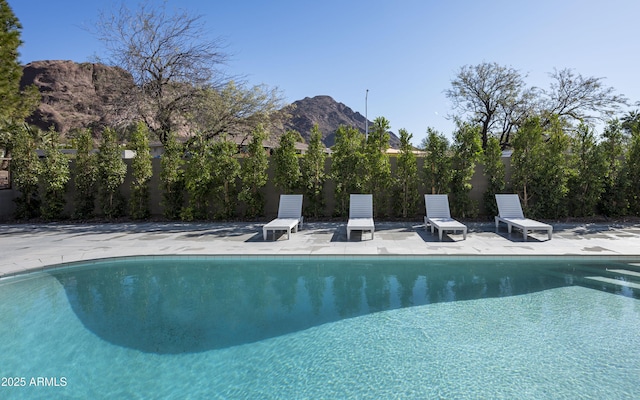 view of swimming pool featuring a mountain view and a patio area