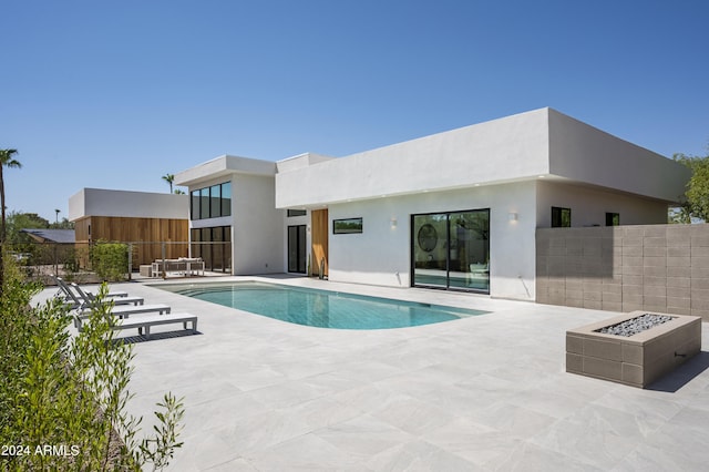 view of swimming pool with a patio and a fire pit