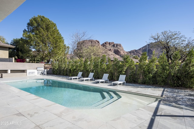 view of pool featuring a mountain view and a patio area