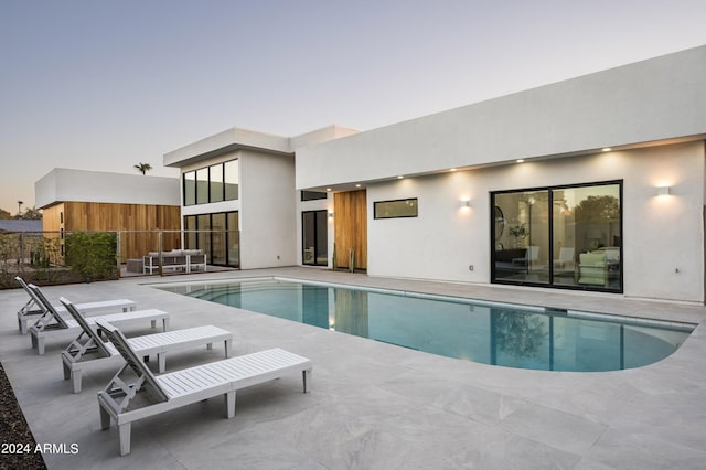 pool at dusk with a patio