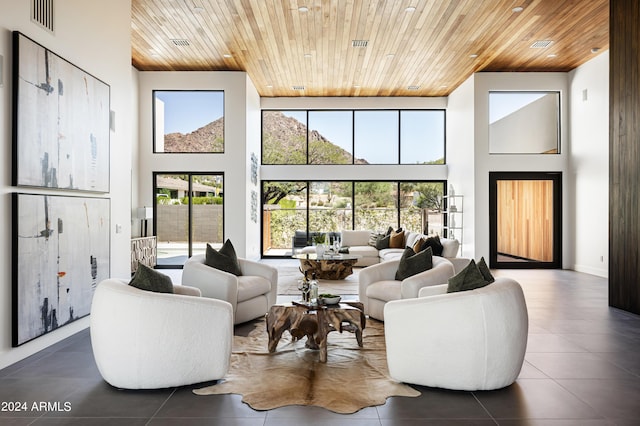 living room with a high ceiling, a wealth of natural light, and wood ceiling