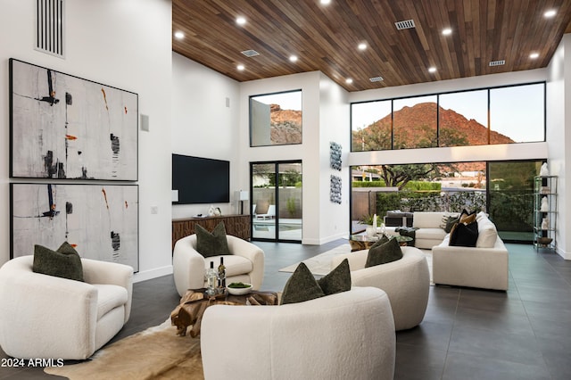 living room with a towering ceiling and wooden ceiling