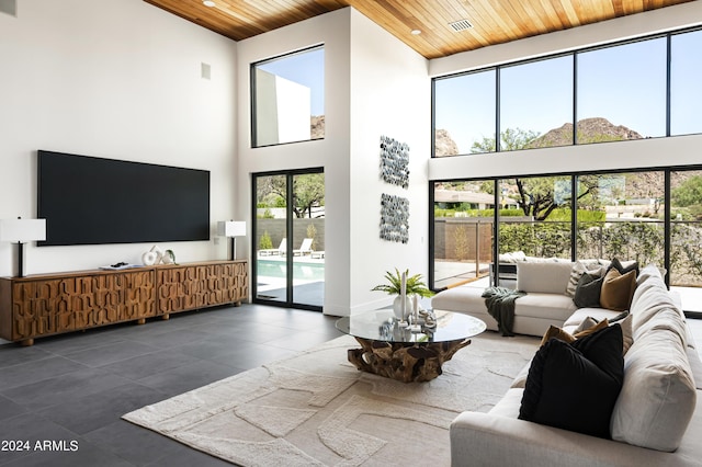 living room with wood ceiling and a high ceiling