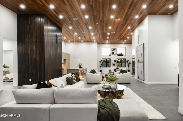 living room featuring a towering ceiling and wood ceiling