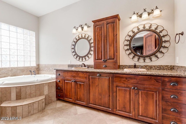 bathroom with tile patterned flooring, vanity, and tiled tub