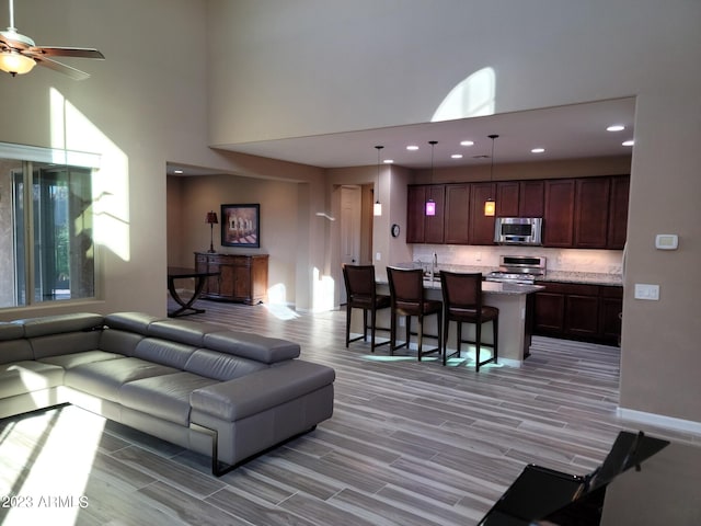 living room with ceiling fan and high vaulted ceiling