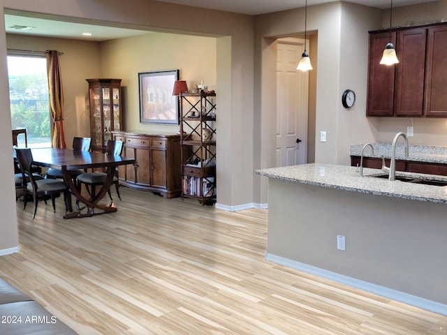 kitchen featuring sink, pendant lighting, and light wood-type flooring