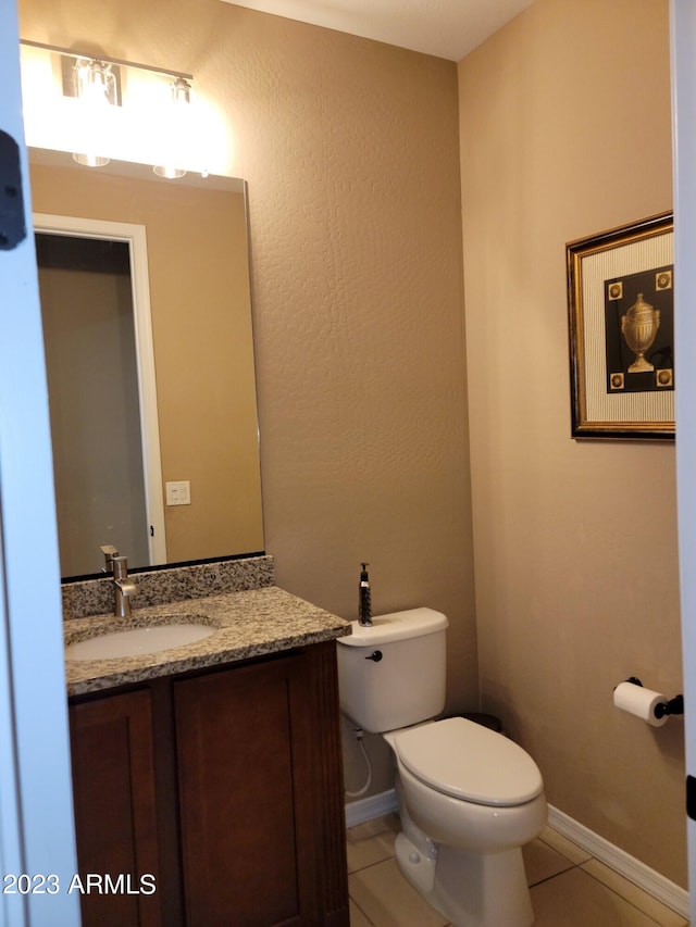 bathroom with tile flooring, toilet, and large vanity