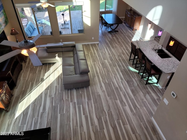 interior space featuring wood-type flooring, ceiling fan, and sink