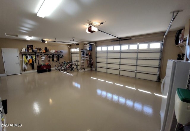 garage featuring white fridge and a garage door opener