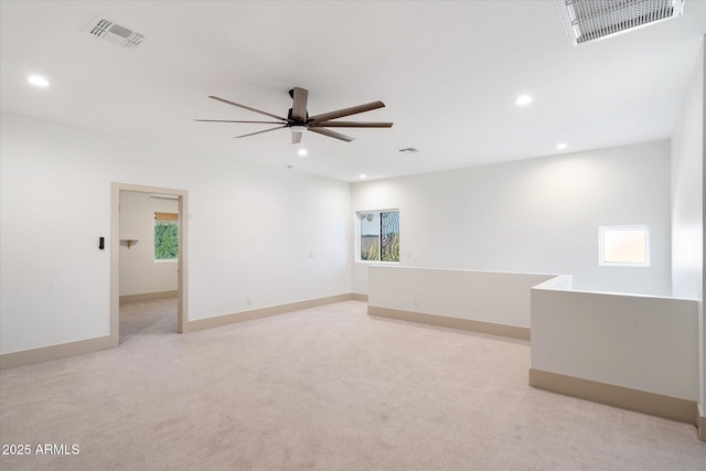 empty room featuring ceiling fan and light colored carpet