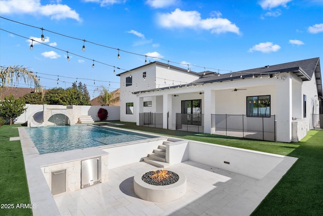 view of pool with an outdoor fire pit, a patio, ceiling fan, exterior kitchen, and a yard