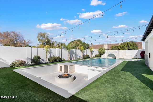 view of swimming pool with a lawn and a fire pit