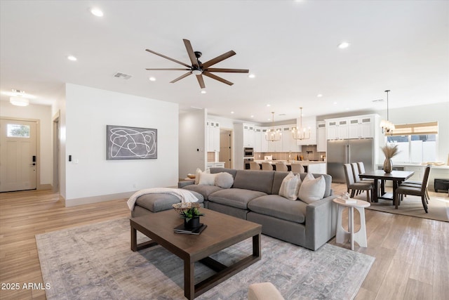 living room featuring ceiling fan and light hardwood / wood-style floors