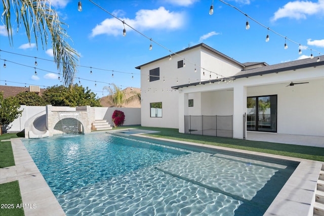 view of pool with a water slide and ceiling fan